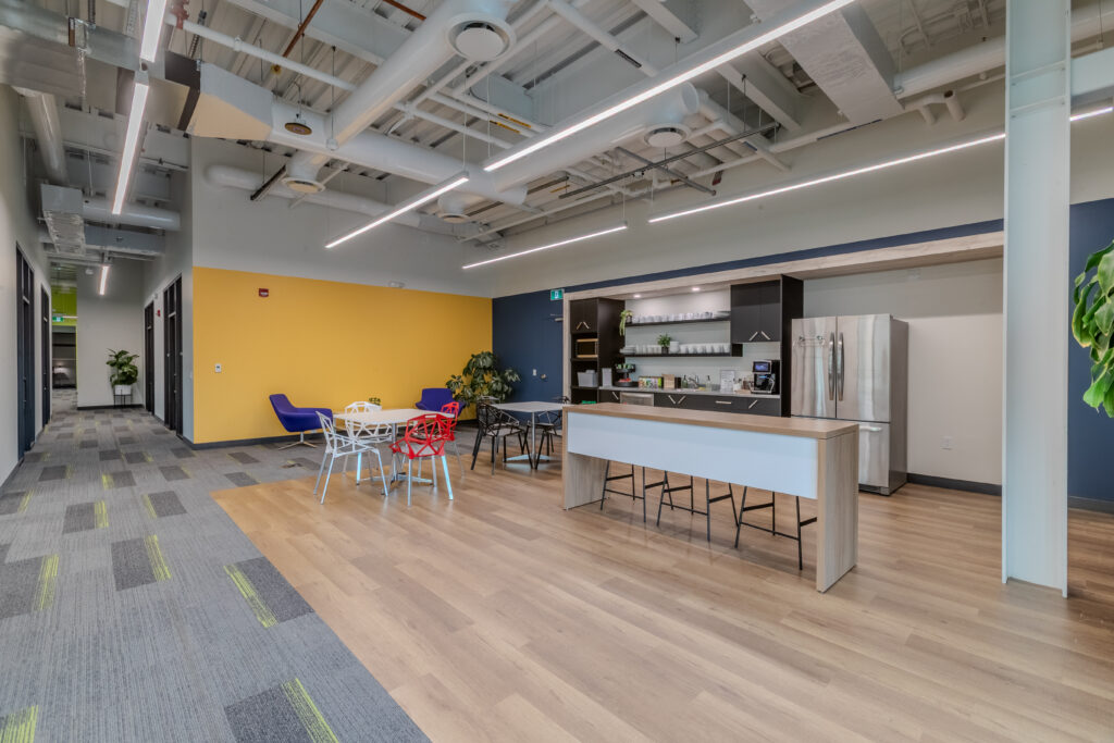 Spacious modern kitchen and lounge area at Cora GRID coworking space in Waterloo, featuring sleek cabinetry, stainless steel appliances, casual seating, and bright natural light for collaborative breaks.