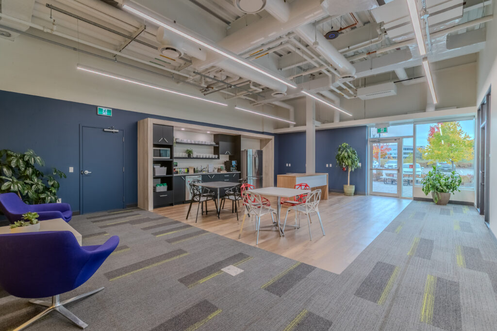 Spacious modern kitchen and lounge area at Cora GRID coworking space in Waterloo, featuring sleek cabinetry, stainless steel appliances, casual seating, and bright natural light for collaborative breaks.